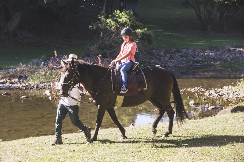Child riding horse by the river